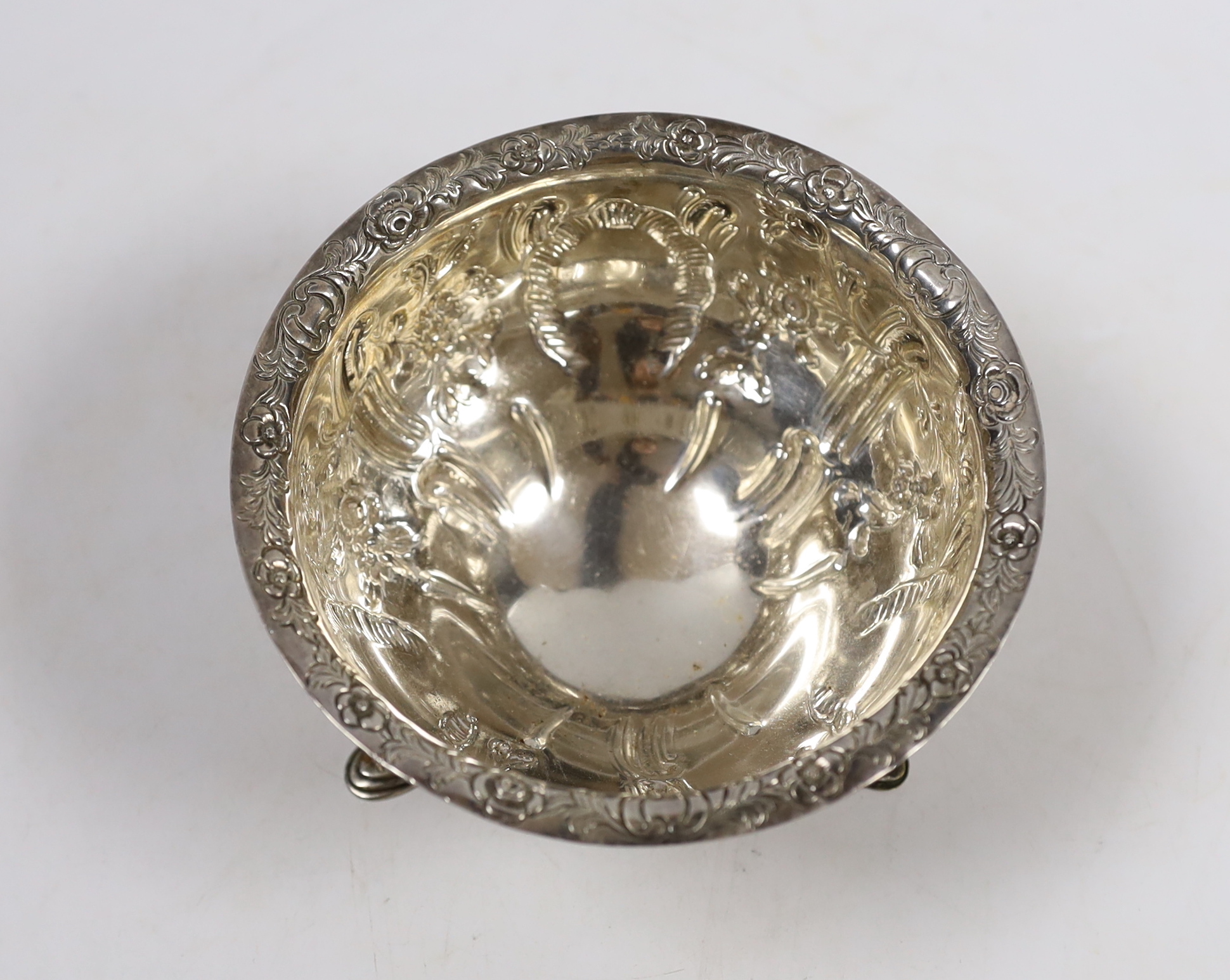 A George V Irish embossed silver circular bowl, on three cabriole legs with hoof feet, West & Son, Dublin, 1913, diameter 12.7cm, 6.1oz.